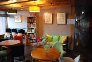 ソギポにあるJeju Eco Suitesのソファ、テーブル、椅子が備わる図書室