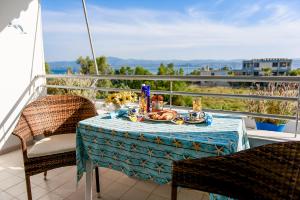 una mesa con un plato de comida en el balcón en Liland Beachfront, en Lefkandi Chalkidas