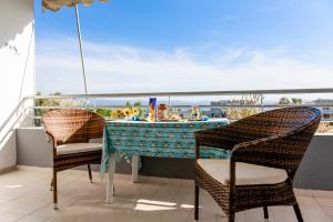 una mesa y sillas en un balcón con vistas al océano en Liland Beachfront, en Lefkandi Chalkidas