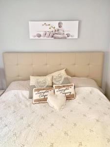 Una cama con dos almohadas y un cartel. en CasaCec, en Alicante