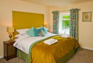 ein Schlafzimmer mit einem großen Bett mit Handtüchern darauf in der Unterkunft Cottage Retreat near Peak District and Chatsworth House in Matlock