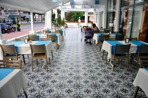 een leeg restaurant met tafels en stoelen in een straat bij Evon Otel in Gazipasa
