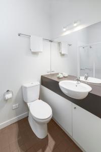 a white bathroom with a toilet and a sink at Southern Ocean Villas in Port Campbell