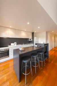 a kitchen with a white counter top and wooden cabinets at Southern Ocean Villas in Port Campbell