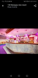 a lobby with a bar with purple lights on it at Newquay Bay Resort Oakley 6 birth caravan in Newquay