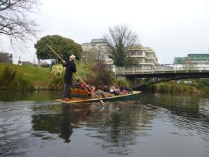 a man riding a boat on top of a river at Argyle on the Park in Christchurch
