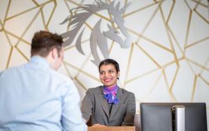 een vrouw aan een tafel voor een computer bij Cheval Harrington Court at South Kensington in Londen