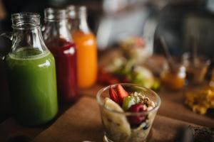 a table with a bowl of food and bottles of green juice at GiG Capsule Hostel in Ericeira