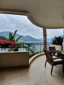 d'un balcon avec une table et des chaises et une vue sur l'océan. dans l'établissement Apartment Maniva, à Kotor
