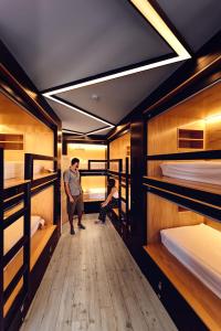 two people standing in a room with bunk beds at GiG Capsule Hostel in Ericeira