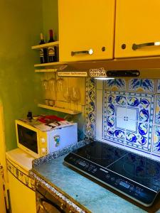 a kitchen with a stove and a microwave at La Finestra sul fiordo in Furore