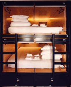 a bunk bed in a room with white pillows at GiG Capsule Hostel in Ericeira