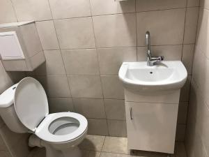 a bathroom with a toilet and a sink at Студио Чайка Бургас Център in Burgas City +5 photos