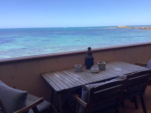 una mesa en un balcón con vistas al océano en La casa dell'Alba, en Marzamemi