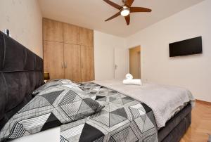 a bedroom with a large bed with a ceiling fan at Kuća za odmor L&L in Bibinje +36 photos