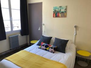 um quarto com uma cama com duas almofadas em Le petit poucet em Saint Lo