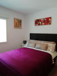 a purple bed in a room with a window at Canovas by the Bull Ring in Málaga