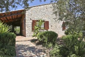 チェファルにあるVillas Vacation Service - Cefalu' Countrysideの庭に木の扉がある石造りの家