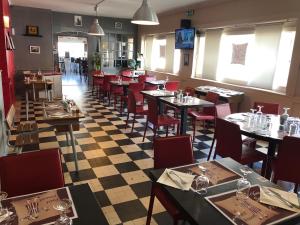 un restaurant avec des tables et des chaises et un sol en damier dans l'établissement Le petit poucet, à Saint Lo