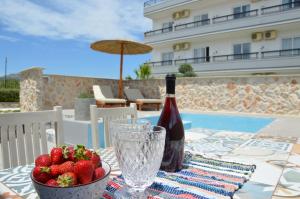 a table with a bottle of wine and a bowl of strawberries at Kostas Studios in Faliraki