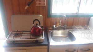 a kitchen with a sink and a tea kettle on a stove at Cabañas Juan Gaviota in Punta de Choros