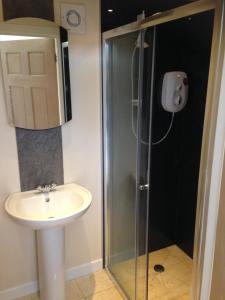 uma casa de banho com um lavatório e um chuveiro em ensuite garden room em Inverness