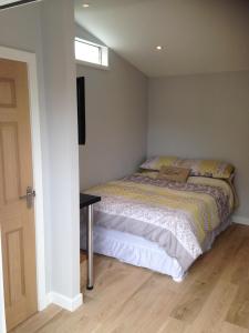 um pequeno quarto com uma cama e uma janela em ensuite garden room em Inverness