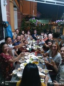 a group of people sitting around a table eating at Countryside Garden Homestay in Hoi An