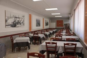 a row of tables and chairs in a restaurant at Hotel Derna in Viareggio