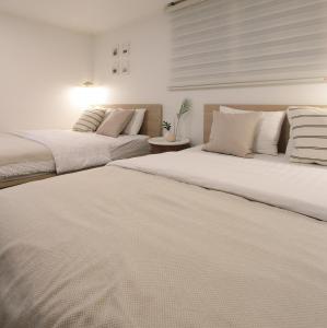 two beds sitting next to each other in a bedroom at Neat House in Seoul