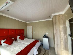 a bedroom with a large bed with a red headboard at Ubuntu Hotel in East London