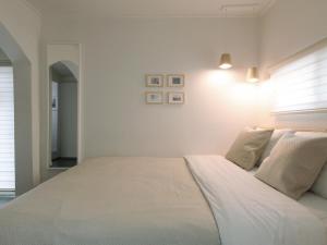 a white bedroom with a large white bed with pillows at Neat House in Seoul