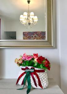 um vaso de flores sentado em uma mesa em frente a um espelho em B&B Bellavista em Tavullia