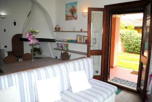 Habitación con mesa, silla y puerta en VILLA STELLA fronte mare Porto Frailis, en Àrbatax 36 fotos más