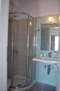 uma casa de banho com um chuveiro e um lavatório. em Romanza Studios em Asos