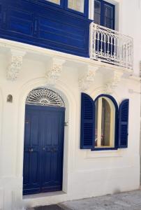 Edificio blanco con puerta azul y balcón en Cosy Studio Maisonette, 8min Walk to Valletta, en Floriana
