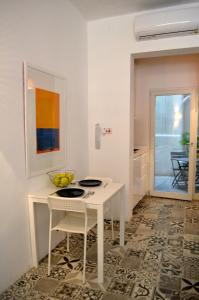 un comedor blanco con mesa y sillas en Cosy Studio Maisonette, 8min Walk to Valletta, en Floriana