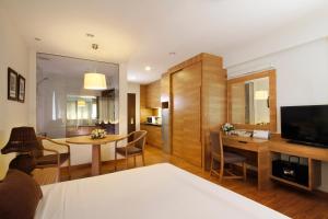 Classic Kameo Hotel & Serviced Apartment, Rayong في رايونغ: غرفة معيشة مع مطبخ وغرفة طعام