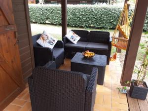 a porch with two chairs and a couch and a table at Chalet Camping Les Vignes in Lit-et-Mixe