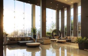 a lobby with couches and tables and large windows at Classic Kameo Hotel & Serviced Apartment, Rayong in Rayong +30 photos