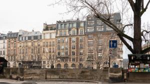 a large building in the middle of a city at 3-bedroom apartment Quai des Grands Augustins in Paris