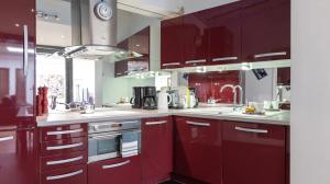 een keuken met rode kasten en een spoelbak bij 3-bedroom apartment Quai des Grands Augustins in Parijs