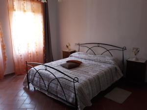 1 dormitorio con 1 cama con manta y ventana en La Casa del Gigli, en Monte San Savino