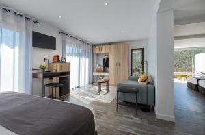 a bedroom with a bed and a living room at Hotel & Spa des Gorges du Verdon in La Palud sur Verdon