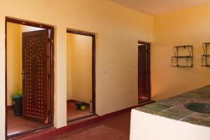 une pièce vide avec deux portes et une chambre avec une pièce dans l'établissement Nomadic Life Camp, à M'Hamid El Ghizlane