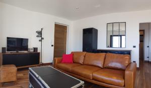 uma sala de estar com um sofá castanho e uma televisão em FONTANA SERI em Ulassai