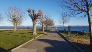 a walkway in a park next to the water at Littoral Lac in Gorgier