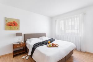 Un dormitorio con una cama con una bandeja de comida. en Swiss Star Wiedikon - Self Check-In en Zúrich