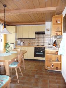 a kitchen with a wooden table and a dining room at Ferienwohnungen Maria Ginther in Pinswang