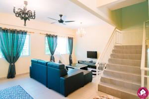 a living room with a blue couch and stairs at Dream Borneo Budget Homestay Kota Kinabalu in Penampang